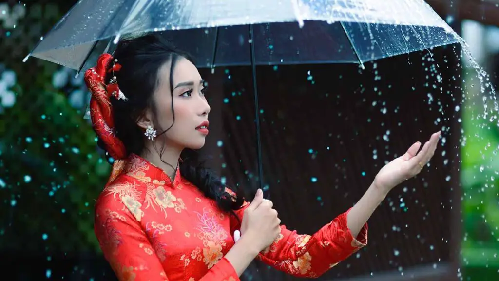 A Girl In Red Outfit Holding Umbrella In Rainy Weather