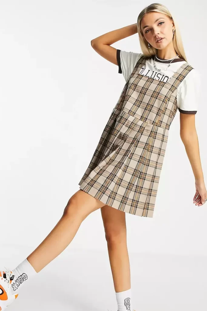 The girl looks like a cute teddy by wearing a pleated mini pinafore dress