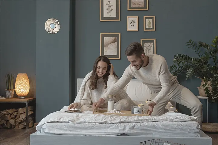 a man serving a romantic Valentine’s Day breakfast with hot coffee in bed