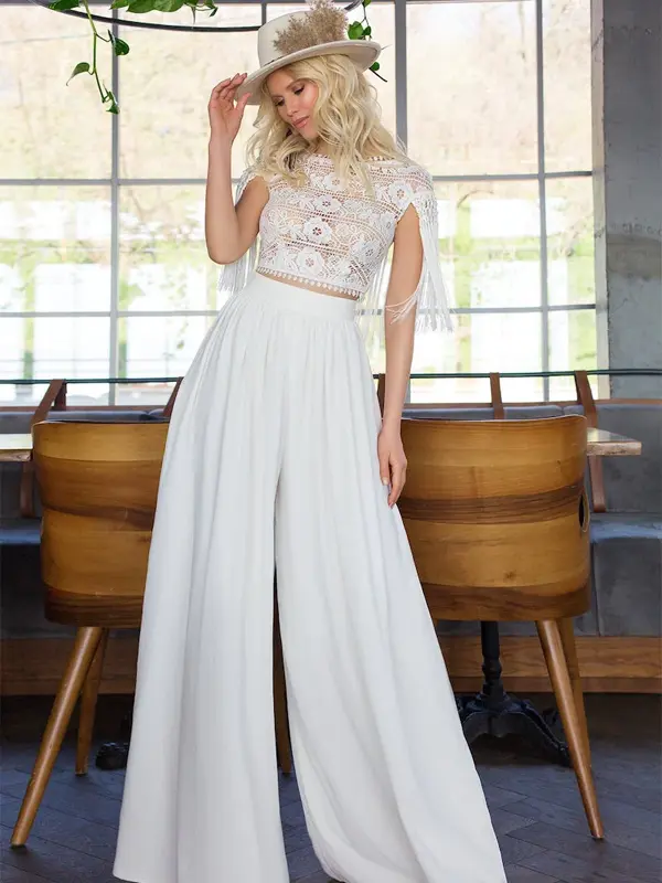 A blonde woman in white palazzo pants and Lace Bralette Top.