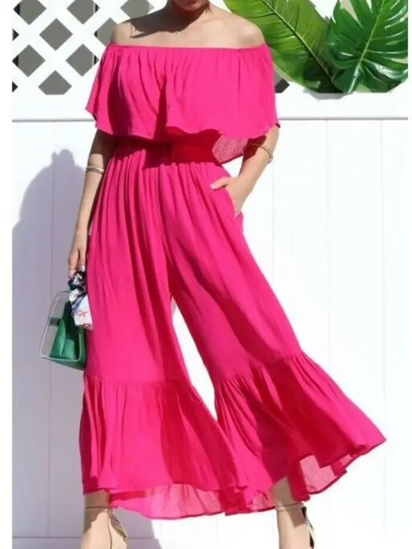 A woman wearing a pink off the shoulder jumpsuit for a wedding.