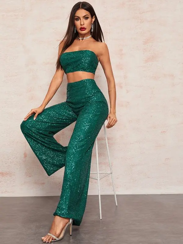 A woman wearing green sequin wide leg Palazzo Pants Set and a crop top.