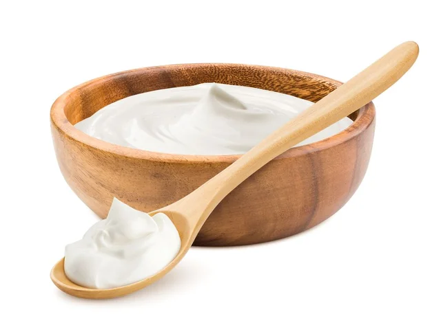 Sour cream in wooden bowl and spoon