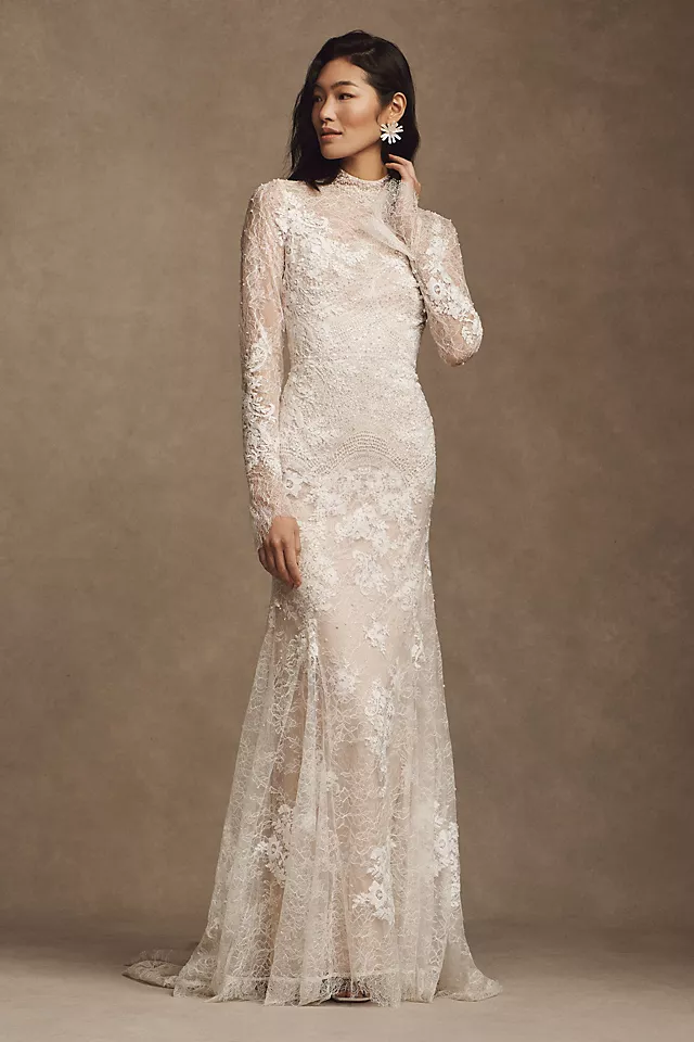 A stunning long-sleeved lace wedding gown with intricate beaded floral details and a flattering fitted waist