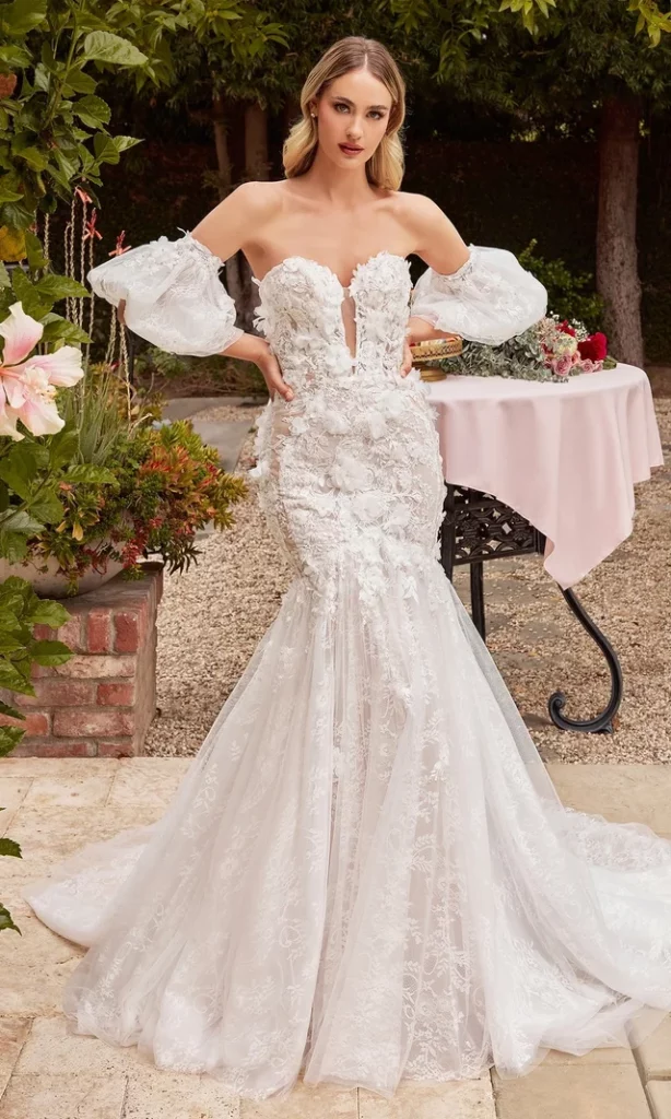 Elegant bride in a detailed lace wedding gown posing in a beautiful garden setting