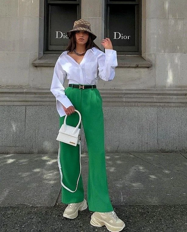 a woman wearing a hat and green pants