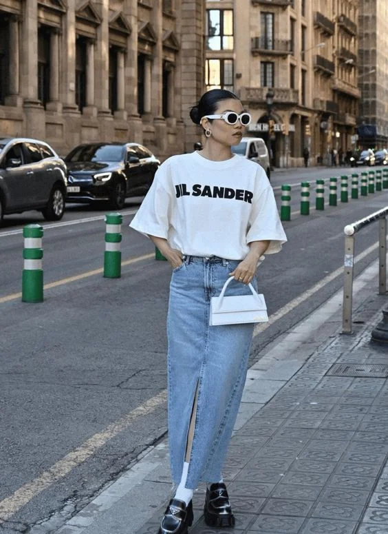 a woman in graphic tee with a denim skirt