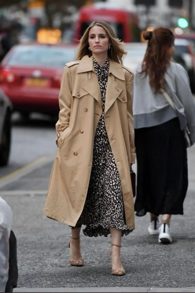 a woman in a trench coat layered over a midi dress