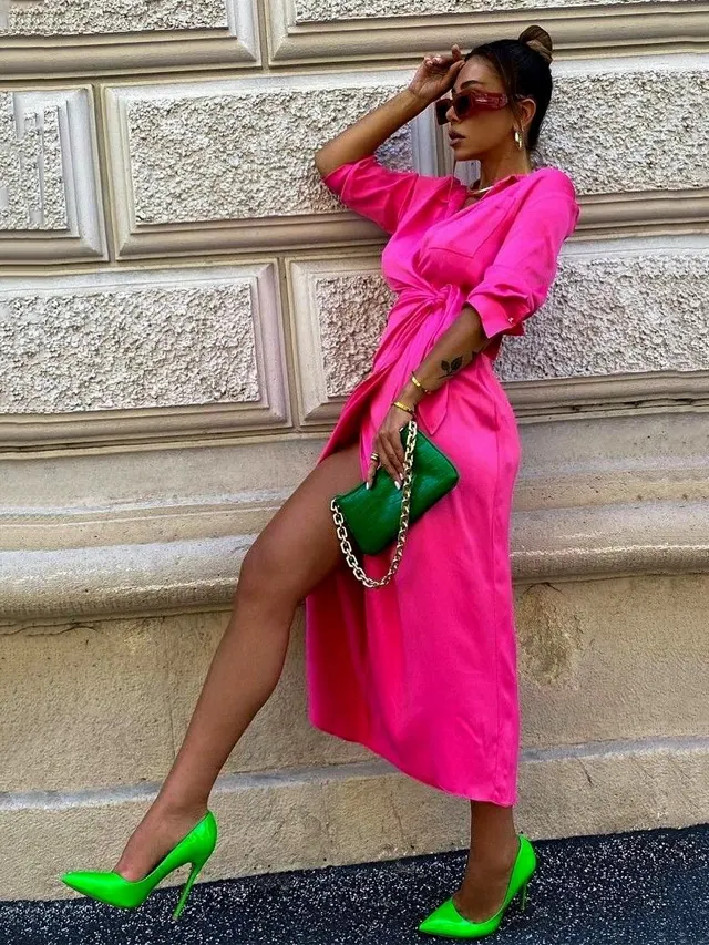Woman wearing a hot pink dress with green shoes